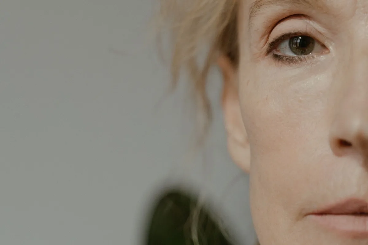 Rosto de mulher madura com pele luminosa e saudável, em close editorial que evidencia a estrutura da face.