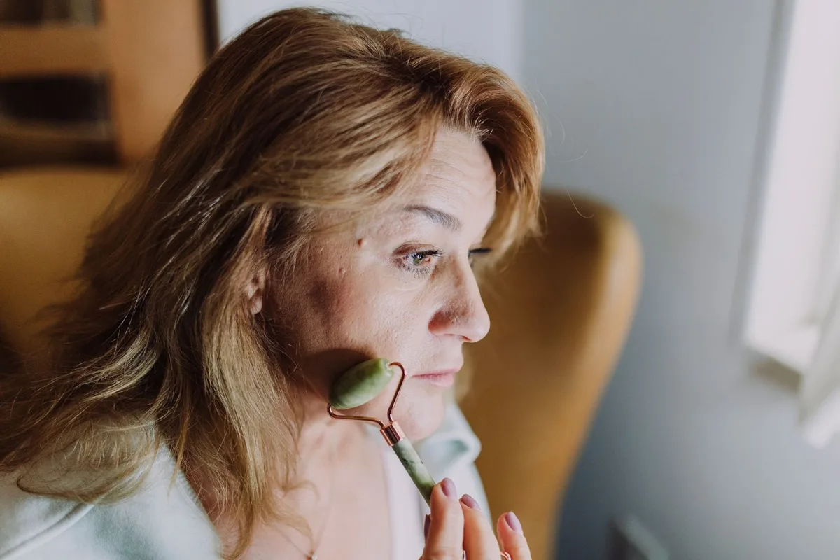 Mulher madura em cuidado facial com pele viçosa e natural, evocando saúde e equilíbrio da barreira cutânea.